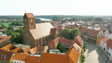 Blick über das mittelalterliche Stadtzentrum Parchims, inmitten grüner Natur.